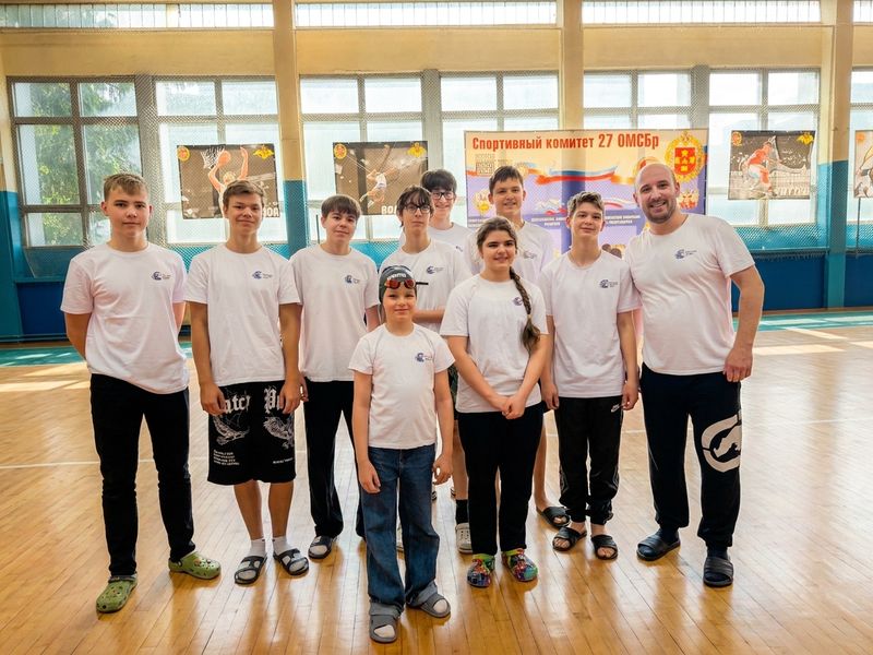 Тренер с командой учеников в спортивном зале